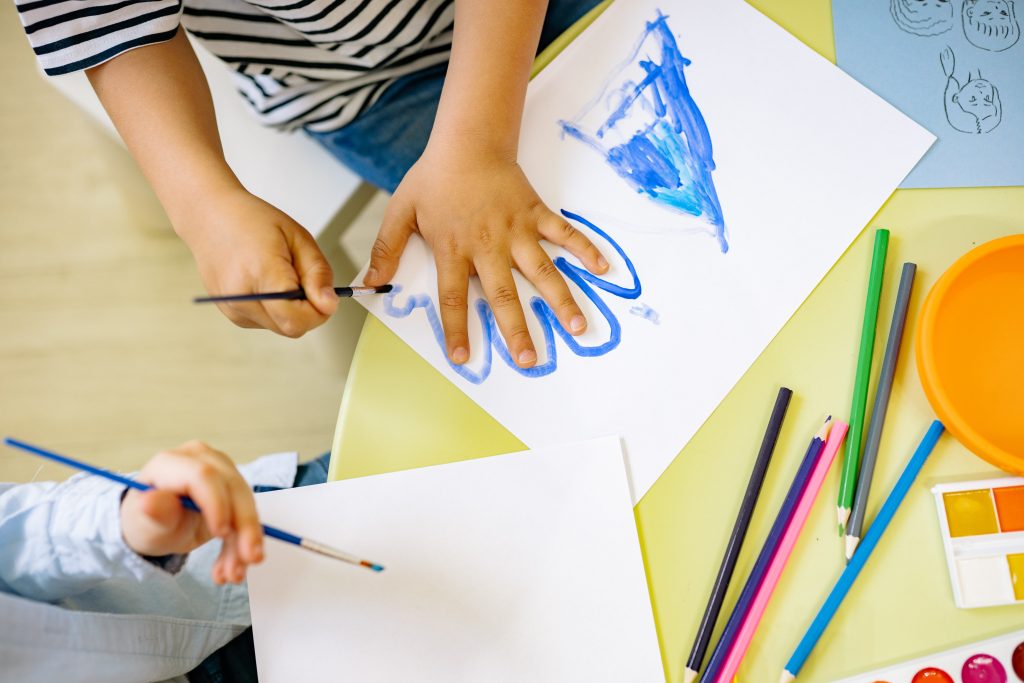 Children painting with blue paint 