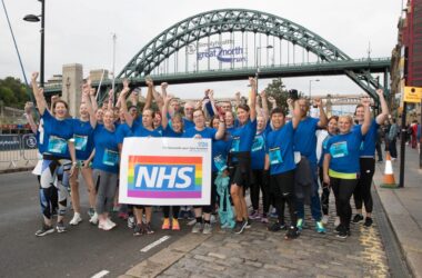 Group of people stood under the Tyne Bridge after completing the Great North Run.